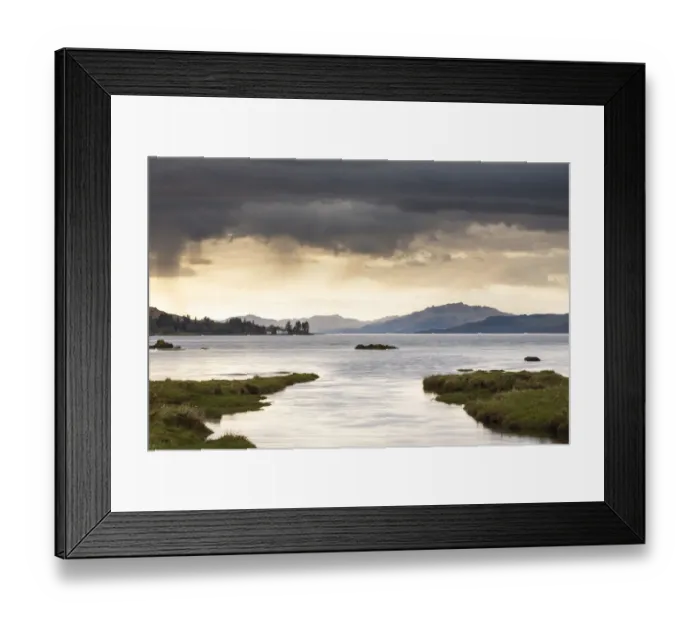 Framed Print : View of meandering river flowing through grassland with hills at background and rain clouds Framed Print : View of meandering river flowing through grassland with hills at background and rain clouds