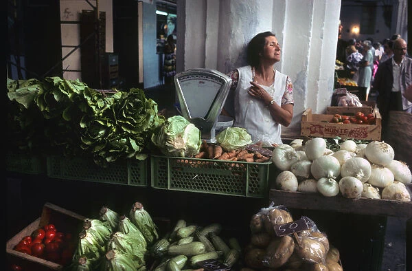 A woman stallholder behind her vegetable stall, Menorca