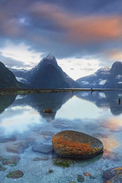 Mitre Peak reflecting in the fjord water at sunset at Milford Sound in New Zealand