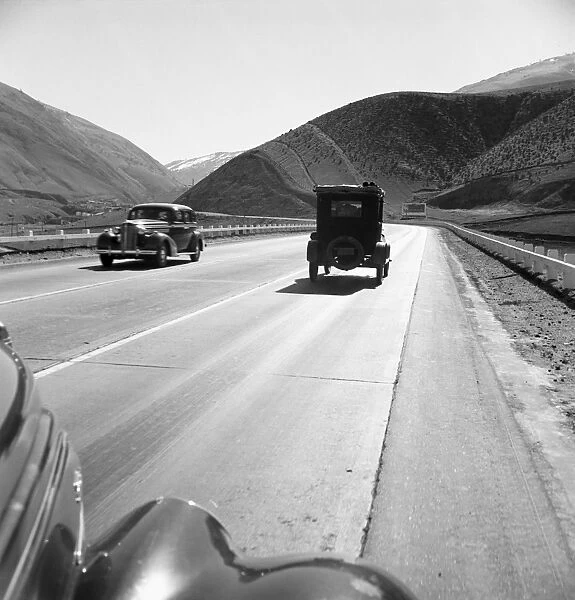 RURAL HIGHWAY, 1939. Migrant workers traveling on U. S. Highway 99 between Imperial and San Joaquin Valleys in Kern County, California. Photograph by Dorothea Lange, February 1939