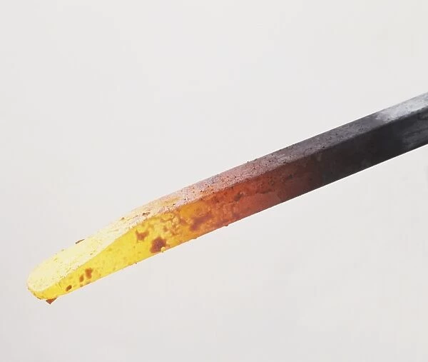 Red-hot metal rod reaching white heat, close up