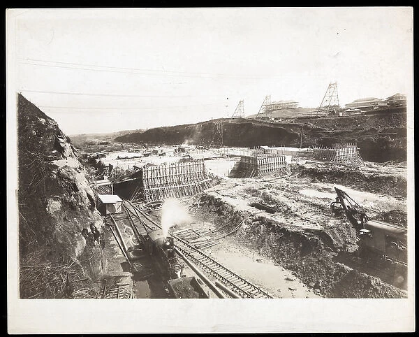 View of construction of the Panama Canal with concrete forms, trains