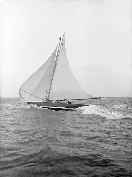 The 7 Metre yacht Pinaster (K8) sailing with spinnaker, 1913. Creator: Kirk & Sons of Cowes