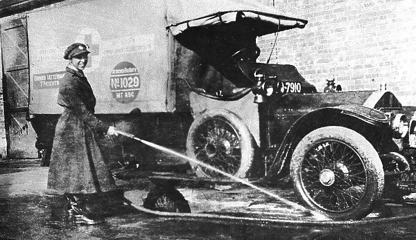 Volunteer English woman driver washing down her ambulance, Cambridge, World War I, 1915