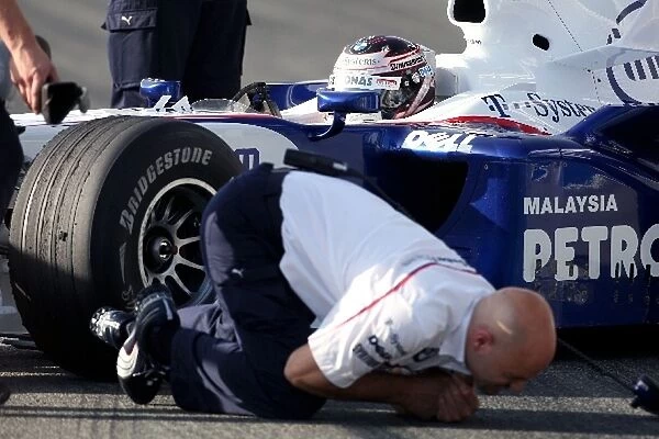 Formula One Testing: A BMW Sauber mechanic receives an electric shock from Christian Klien BMW F1. 08 running a KERS system