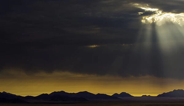 the sun breaks through the clouds in namibia, Namibia