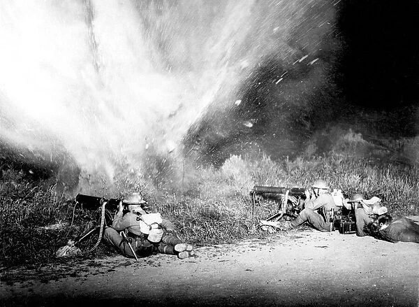 Machine gunners firing while a mine explodes just in front of them during a live firing