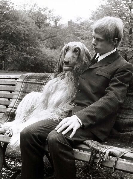 A man sitting on a park bench with his Afghan hound May 1967