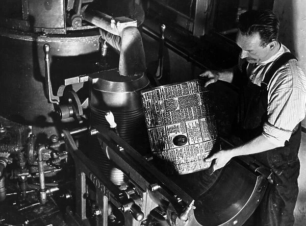 Printers Circa 1950 Printer places a hot metal plate on a printing press