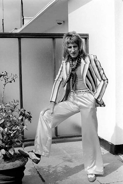 Rod Stewart poses wearing trousers and striped jacket. 24th July 1975
