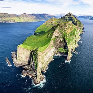 Aerial view of Kallur lighthouse on majestic cliffs washed by the blue Atlantic ocean, Kalsoy island, Faroe Islands, Denmark, Europe