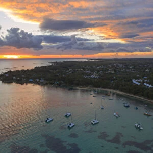 Orange sky at sunrise over the tropical beach and lagoon, aerial view, Grand Baie