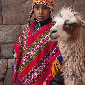 South America, Peru, Cusco. A Quechua boy in a poncho and a chullo woollen cap with