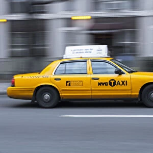 USA, New York, New York City, yellow city cab speeding along a New York street