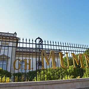 A wrought iron fence and golden letters in the setting sun at at Champagne G. H