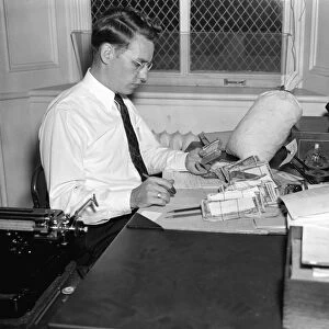 COUNTERFEIT CURRENCY, 1938. A Secret Service agent checking over confiscated counterfeit