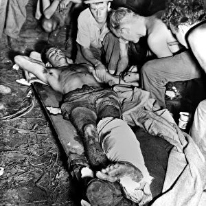 WORLD WAR II: NEW GUINEA. A wounded American soldier receives a blood transfusion