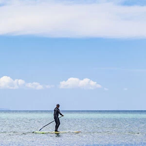A paddleboarder at Orewa in Auckland Region, New Zealand
