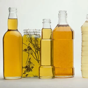Clear glass or plastic bottles filled with different types of infused oils
