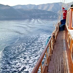 Looking back at the wake of Turkish gulet sailing among Greek islands in early morning