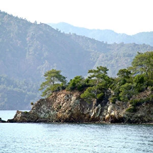 Rocky promontary with mountain backdrop on south Turkish coast near Fethiye