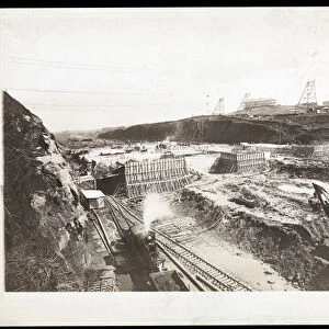View of construction of the Panama Canal with concrete forms, trains