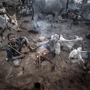 Two mundari children in the heat of a bonfire - South Sudan