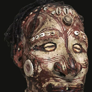 Human skull with features modelled in clay and painted, from New Guinea