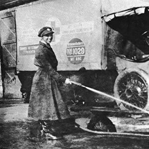 Volunteer English woman driver washing down her ambulance, Cambridge, World War I, 1915