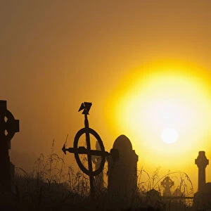 Sunrise at aghadoe heights graveyard with silhouetted tombstones; Killarney, county kerry, ireland