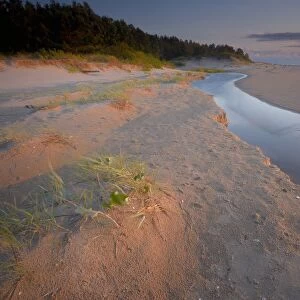 Little river flows over the beach in Slitere National Park, before ending in the Baltic Sea