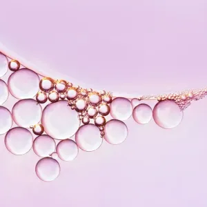 Kette aus Wassertröpfchen gegen ein rosa Hintergrund