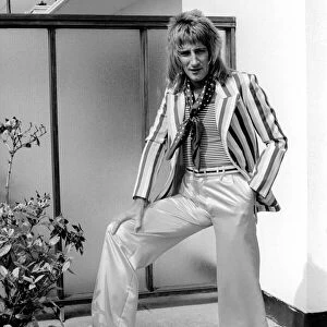 Rod Stewart poses wearing trousers and striped jacket. 24th July 1975