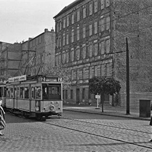 A tram runs along Bernauer Strasse, Berlin. The buildings on the east side of the street