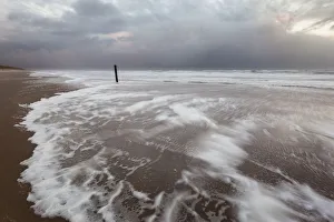 Foam on North Sea beach at stormy winter day, North Sea beach, the Netherlands Foam on North Sea beach at stormy winter day, North Sea beach, the Netherlands