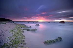 A sunset over the Gulf of Finland at the coast of Lahemaa National Park with boulders A sunset over the Gulf of Finland at the coast of Lahemaa National Park with boulders